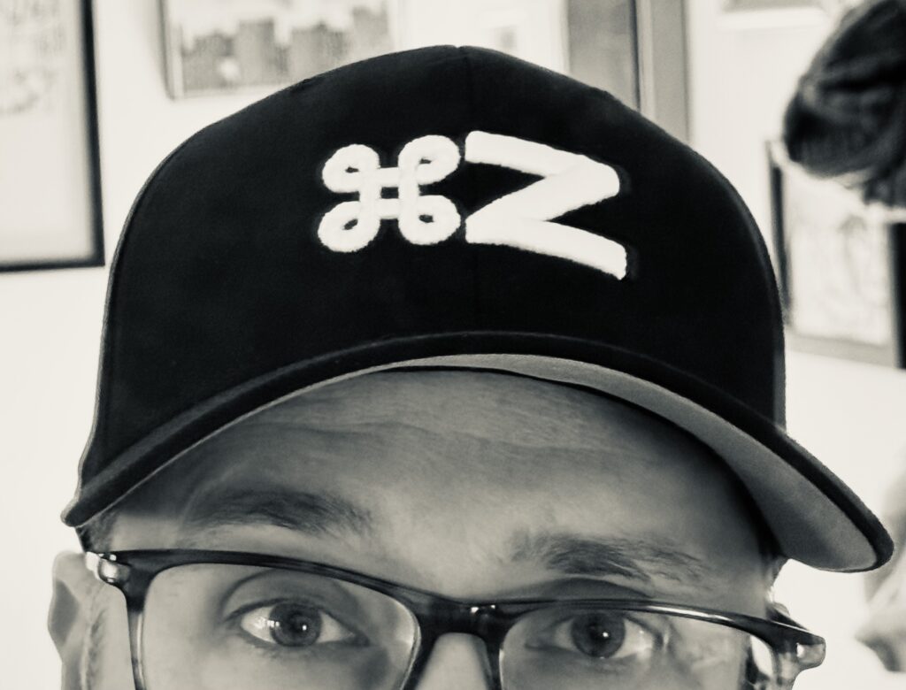 The upper half of the face of yours truly, wearing a fashionable black baseball cap embroidered with the Command Z logo.